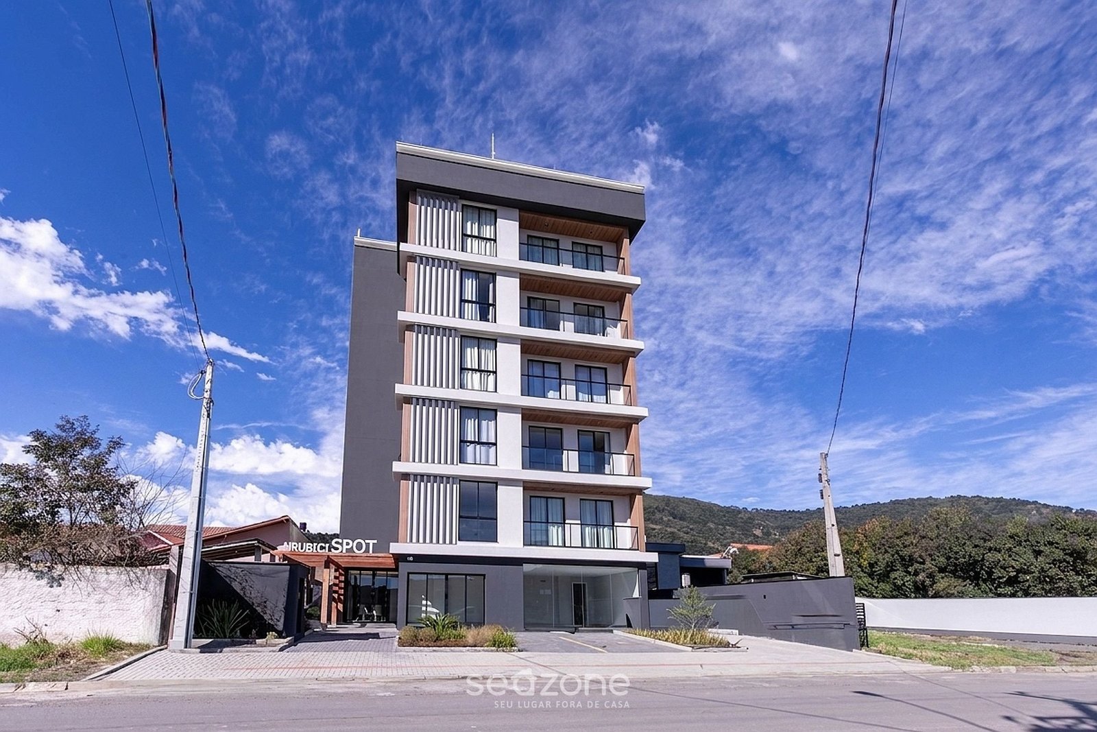 Fachada completa do edifício Urubici Spot com a serra ao fundo