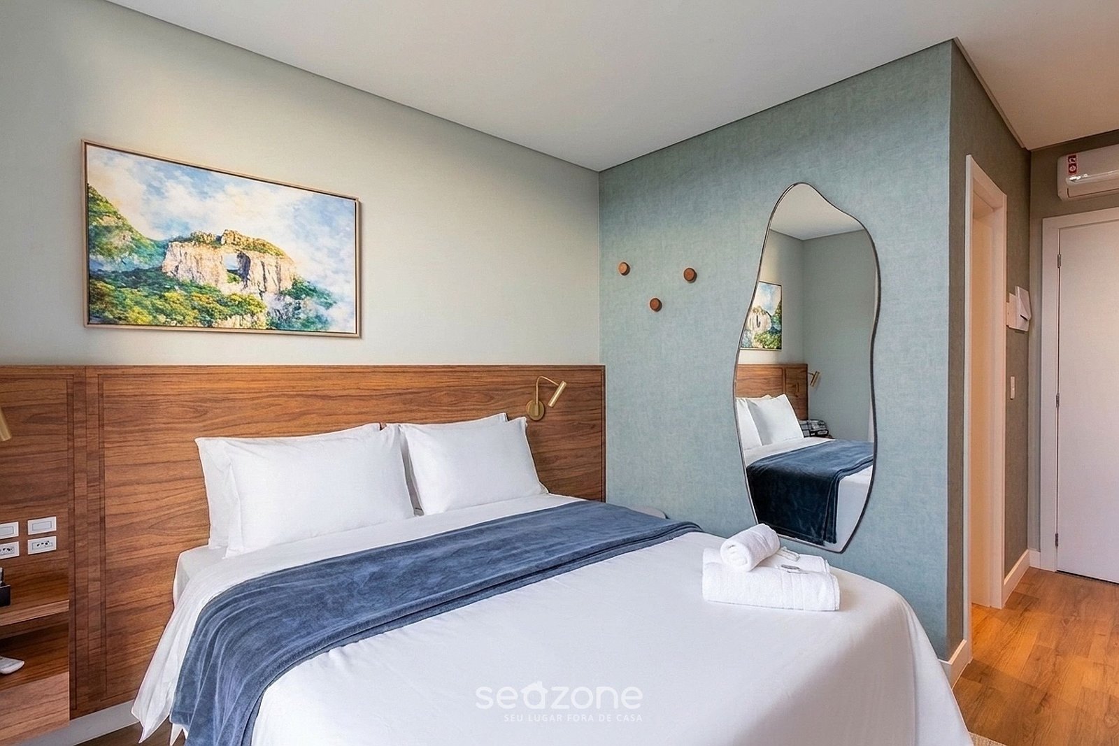 Quarto do estúdio com cama de casal e quadro da Serra Catarinense